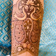 This bridal arm band design features two peacocks forming a heart shape, with a lotus blooming above them. It's a very romantic and popular motif for brides.