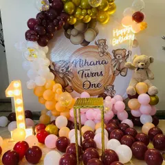 A classic and cute teddy bear theme for a first birthday. This setup features a custom backdrop with a wood-grain print, an organic balloon arch in earthy tones, and a light-up number '1'.