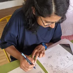 A participant focused on her doodling worksheet. Our workshops provide prompts and guidance to help you get started with this fun and freeform art style.