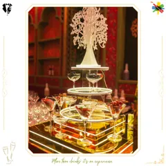 This elegant bar setup uses a tiered, illuminated display and a decorative tree centerpiece to create a visually stunning focal point. The design combines modern lighting with classic elegance for a luxurious feel.