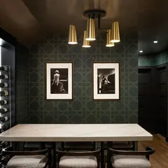 A sophisticated wine cellar featuring the 'Styled in Studs' collection from Phillip Jeffries. The refined geometric pattern adds a touch of modern charm and understated luxury, perfectly complementing the dark, moody ambiance.