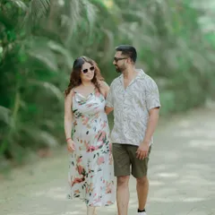 A sweet, walking-and-talking shot of a couple in a tropical setting. Their smiles and easy-going posture show a comfortable and happy connection.
