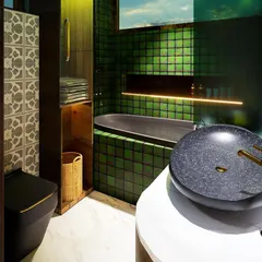 This moody and luxurious bathroom is another intern's design. It combines a dark palette of green tiles and black ceramics with brushed bronze fittings and patterned tiles to create a vintage yet modern feel in a 70 sq.ft. space.