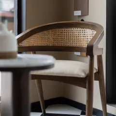A classic dining chair from House of Goya, featuring a curved wooden frame and a caned backrest. This piece blends timeless craftsmanship with modern comfort, perfect for any elegant dining space.