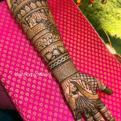 A full-arm bridal mehendi with a beautiful bride portrait on the palm. The design extends all the way up the arm with bands of traditional motifs, including elephants and floral patterns.