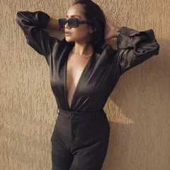 This final shot from the black suit series captures a more dynamic pose, showcasing the fit and movement of the outfit. It completes the visual story, providing a comprehensive look at the apparel for a brand's lookbook or social media campaign.