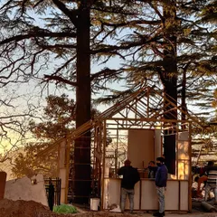 The cafe kiosk under construction amidst the deodar trees. This image captures the process of creating a new community nerve center, using local building techniques and materials to ensure the structure belongs to its environment.