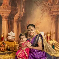A beautiful portrait of a mother and her baby dressed as little Krishna. The ornate backdrop and traditional attire create a stunning and memorable festive photograph.