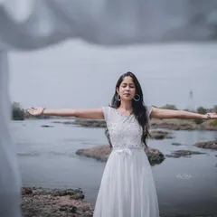 A close-up of the bride-to-be in a free-spirited pose. The focus is entirely on her serene expression and the beautiful natural setting.