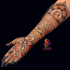 An elbow-length bridal design that showcases a variety of traditional Indian mehndi patterns. The artwork features peacock figures on the arm, surrounded by intricate floral and geometric fillers.