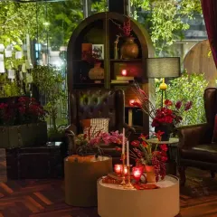 This cozy nook was styled to feel like a classic study, with leather wingback chairs, an arched bookshelf filled with curios, and warm, intimate lighting from vintage-style lamps.