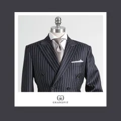 The double-breasted pinstripe suit is an icon of sartorial power. Our meticulous tailoring is evident in the balanced peak lapels and structured shoulders, creating a garment that is both classic and contemporary.