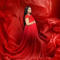 I love playing with fabric to add movement and drama. Here, the flowing red material surrounds the mother to be, creating a sense of energy and elegance in this studio portrait.
