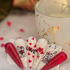 Sending love from my nails to yours. This Valentine's Day set is all about romance, featuring glittery red nails, tiny hearts, and cute, hand-painted lovebird characters.