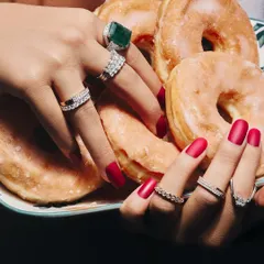 How many rings are too many? The truth is, it is never enough. This image captures the joy of a full ring stack, featuring a mix of diamond bands and a statement emerald cocktail ring.