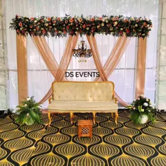 A simple yet classic stage decoration for an intimate engagement. I used elegant beige drapes, a vintage-style sofa, and a thick floral runner with a small chandelier to create a sophisticated and timeless look.