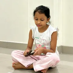 A young learner practices with her claves and notation cards. The simplicity of the tools allows for a clear focus on the core musical task: understanding and reproducing rhythmic patterns.