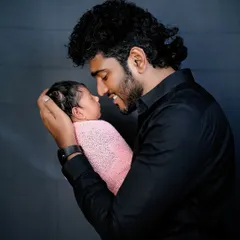 A proud father looking at his newborn baby. The bond between a dad and his new child is so powerful, and I love capturing it on camera.