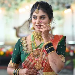 The joy on a client's face is my biggest reward. Here is a beautiful bride looking radiant in her custom-designed green blouse with delicate embroidery that perfectly complements her traditional red and gold wedding saree.