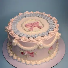I'm obsessed with bringing back old-world charm. This vintage Lambeth cake features delicate pastel pink and blue ruffles, a sweet bow, and hand-piped floral details. It’s all about creating an elegant centerpiece that marks the beauty of an occasion.