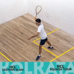 A player demonstrating perfect form and court positioning during a competitive match at the HCL Squash Tour in Kolkata.