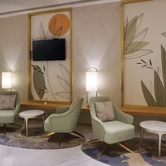 The main lounge area at the VVIP Lounges in Bangalore International Airport's Terminal 2. We designed this space to feel verdant and serene despite having no natural light, using a soft green color palette, custom lighting, and botanical-themed wall panels to create an oasis for travelers.