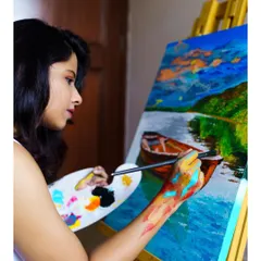 A side profile of me working on a vibrant landscape painting. You can see my paint-covered hand, a true sign of getting lost in the work.
