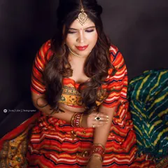 For this festive Navratri photoshoot, we created a look that is both traditional and glamorous. The makeup features a classic winged liner, a bright red lip, and a touch of gold on the eyes to match the vibrant, colorful attire.