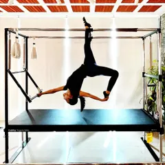 Discover how Pilates enhances your mental well being. This graceful pose on the Cadillac is as much about focus and mental clarity as it is about physical strength.