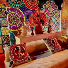 A closer look at the seating arrangement for a Rajasthani-themed event. The custom-printed cushions and colorful backdrops create a cohesive and visually rich environment for guests to relax in.
