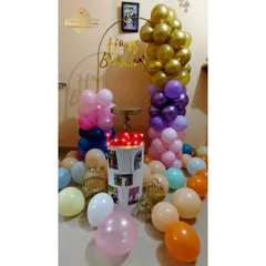 A compact and colorful home birthday decoration with balloon columns and a personalized photo plinth.