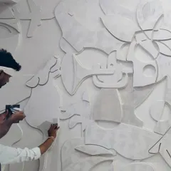 Our team meticulously working on a 3D plaster mural, sanding and shaping each element by hand to create a seamless, tactile surface.