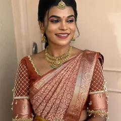A radiant look for a client's pre-wedding rituals, featuring a simple side-parted hairstyle that complements her traditional attire.