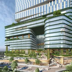 A closer view of the NESCO Centre's unique architecture, highlighting the large void that creates a visual and physical connection through the building. The design incorporates extensive greenery on multiple levels.