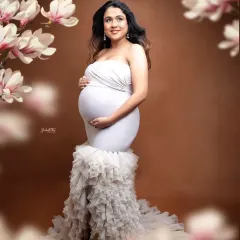 A truly angelic portrait. The mom-to-be in a white mermaid gown is framed by soft floral overlays, creating a dreamy and ethereal fine art maternity photo.