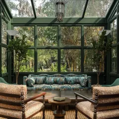 A cozy seating nook, where a custom-printed sofa and chairs are set against the backdrop of the garden. The design blurs the line between the interior and the exterior.