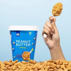 A simple, effective shot that highlights the delicious texture of creamy peanut butter. The hand holding up the spoonful makes the product feel instantly craveable and ready to eat.