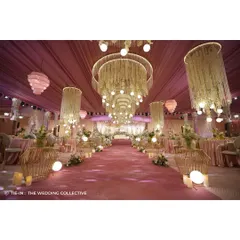 For this 'Midsummer Dream' reception, we created a magical, ethereal ambiance. The hall is dominated by grand, custom-made chandeliers dripping with thread curtains and flowers, casting a warm glow over the blush-pink decor and demonstrating our expertise in lighting and custom fabrication.