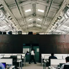 The main workspace at the ATE Pune facility is located within the retrofitted factory shed. The design preserves the original trusses and high ceiling, creating a voluminous and inspiring open-plan office with a distinct industrial character.