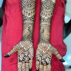 A stunning example of peacock-themed mehandi. The design features graceful peacocks on the arms and intricate floral and paisley patterns covering the hands.