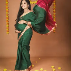 A beautiful mom-to-be in a green and pink silk saree, with her pallu flowing gracefully. The traditional marigold flower decorations add a festive and cultural touch to this maternity portrait.