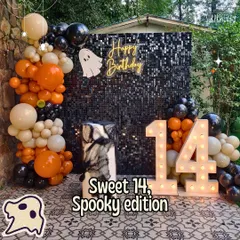 Sweet 14, spooky edition! For this Halloween-themed birthday, I created a dramatic photo booth with a black shimmer wall, an orange and black balloon garland, and a "Happy Birthday" neon sign.