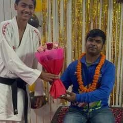 A senior student with a black belt expressing his respect, a core value we teach alongside karate techniques.