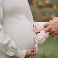 A creative shot where the father's hands bring the baby's first shoes up to the bump. This is a lovely way to include your partner in the photos and symbolize the family you are becoming.