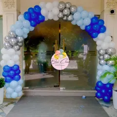 A classic balloon arch in blue, white, and silver, creating a grand entrance for a party.