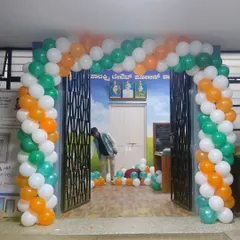 A balloon arch in saffron, white, and green at the entrance of a government office for a national holiday.