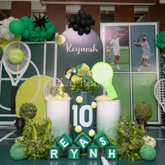 The main stage for a tennis-themed 10th birthday, designed to look like a tennis court with a net, rackets, and a vibrant green and black color scheme.