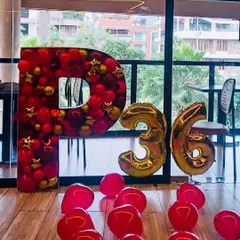 Custom mosaic letters are a great way to personalize a simple setup. This 4-foot tall letter 'P' is filled with red and gold balloons and paired with number foils for a 36th birthday.