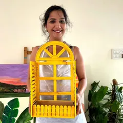 A participant proudly holding the cheerful yellow window-style planter she created in my wood distressing workshop. It's a perfect, rustic-chic addition to any home.