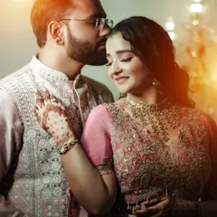 A tender moment from a Roka ceremony. The groom kisses the bride's forehead, and the warm lighting adds to the romantic and intimate feel of the photograph.